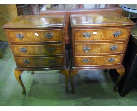 A pair of Georgian style lamp or bedside chests, each of bow fronted outline, enclosing three frieze drawers, raised on shape