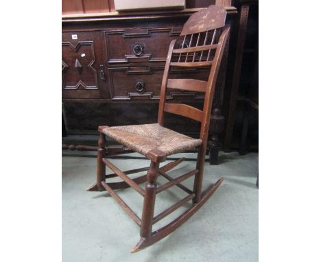 A 19th century American cottage rocking chair with ladder and stick back, rush seat and turned rails