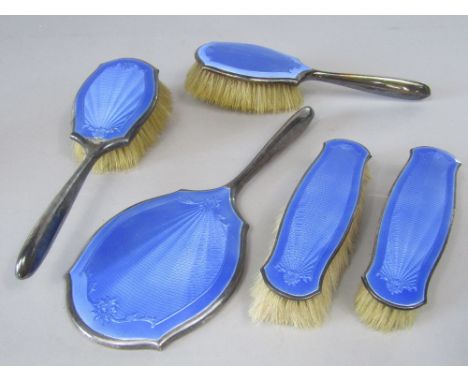 A 1920s five piece silver and guilloche enamel dressing set comprising four various brushes and a mirror