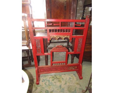 A Chinese red lacquered floorstanding screen, the moulded framework incorporating decorative pierced panels beneath dog of fo