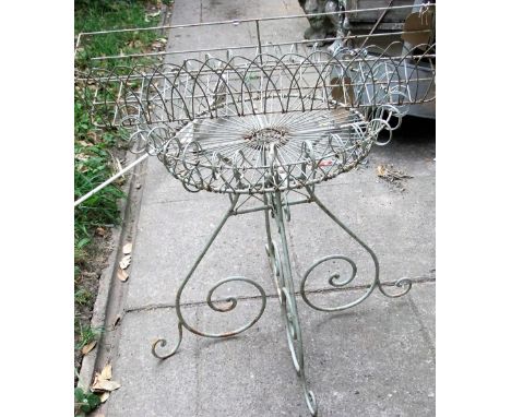 A decorative light steel and wirework conservatory/garden planter with circular shallow basket raised on scrolled supports, t