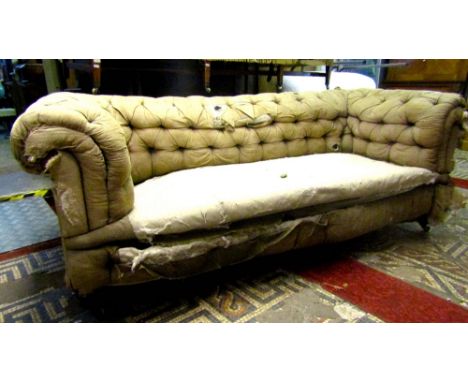 A Victorian three seat Chesterfield sofa with deep buttoned back and rolled arms and raised on turned supports and castors, f