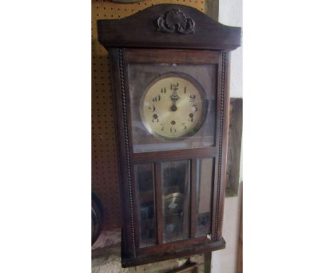 A vintage oak cased drop dial wall clock, with three train dial, 75cm high 