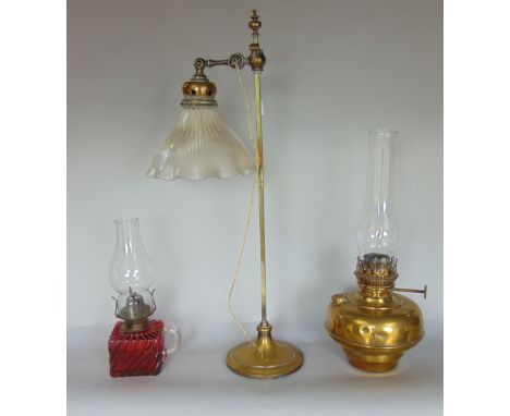 Attractive arts and crafts brass adjustable table/desk light with rippled glass shade, together with two further oil lamps (3