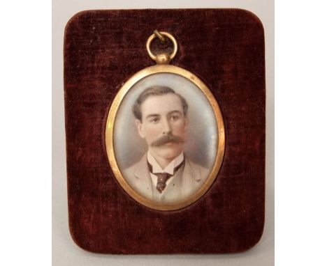 An early 20th century school - bust portrait of a stylish gentleman, miniature work on ivory, within a gilt brass pendant and