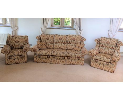 A good quality contemporary three seat sofa with floral patterned upholstery on a beige ground, scrolled arms, wing back and 