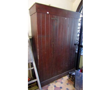 A vintage rustic stained pine side cupboard of tongue and groove boarded construction, floorstanding and enclosed by a centra