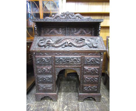 A good quality Chinese bureau with deep relief carved detail throughout, depicting writhing dragons, within further scroll wo