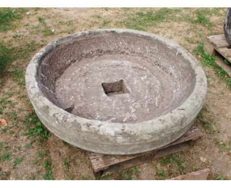 A good and unusual natural stone trough of squat circular form, with central square drainage hole approx 105 cm in diameter x