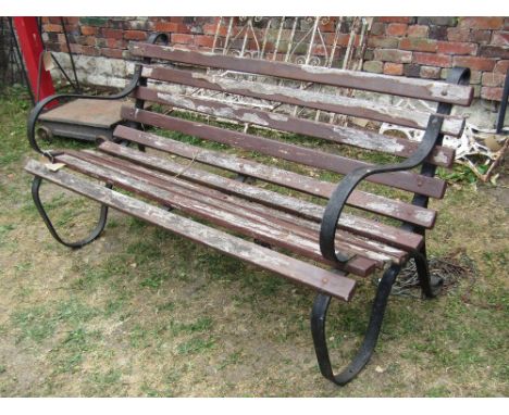 A two to three seat garden bench with wooden open slatted seat and combined back raised on a pair of sprung steel supports, l