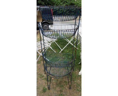 A vintage coated light steel framed stand housing  four bow fronted wirework baskets together with a pair of vintage Singer c