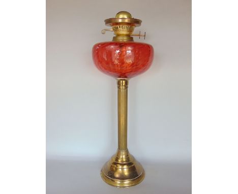 Brass Corinthian column oil lamp with cranberry type reservoir, 50cm high