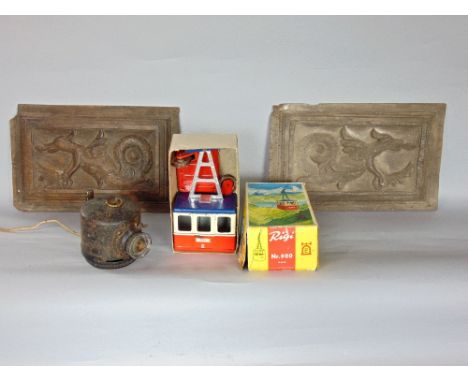 A pair of carved antique oak panels of coiled dragons together with a further tin plate toy of a chair lift and  a WWII signa