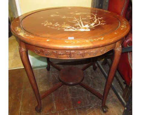 A Chinese hardwood occasional table of circular form raised on four pad feet with under shelf, with mother of pearl, landscap