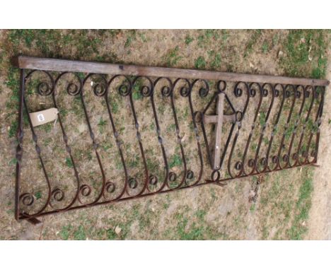 A reclaimed ecclesiastical run of railing with simple scroll work detail flanking a central wooden crucifix beneath a moulded