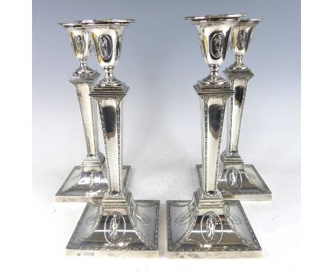 A set of four Victorian silver candlesticks in the neo-classical Adam style, having tapering classical columns with floral bo