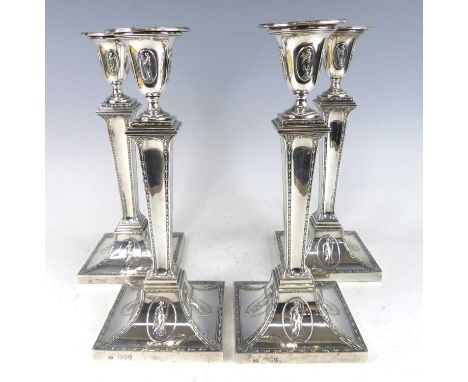 A set of four Victorian silver candlesticks in the neo-classical Adam style, having tapering classical columns with floral bo