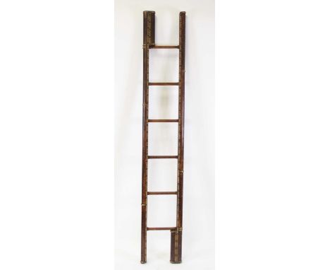 A vintage oak and studded hide bound metamorphic ladder, having six steps and folding into a single pole, h.206cmStructurally