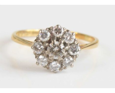 A yellow and white metal diamond circular cluster ring, featuring a centre round brilliant cut diamond within a border of eig