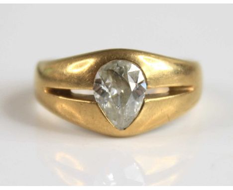 A yellow metal diamond solitaire ring, featuring an old pear cut diamond flush set within a boat shaped head, diamond dimensi