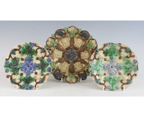 A pair of Edward Bingham of Castle Hedingham polychrome glazed pottery dishes, circa 1890, each relief decorated with masks a