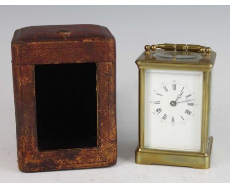 A late 19th century French lacquered brass carriage clock, having an unsigned white Roman dial, swing carry handle above a vi
