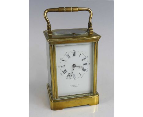 A late 19th century French lacquered brass cased carriage clock, the white enamel Roman dial signed by the retailer Primavesi
