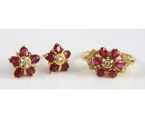 A yellow metal ruby and diamond ring and earring set, the ring designed as a circular cluster with six oval rubies and eleven