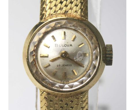 An 18ct yellow gold lady's Bulova manual wind wristwatch, having a round silver baton dial and diamond cut pattern in glass, 