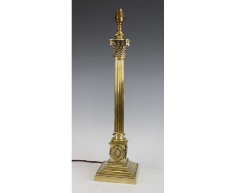 A late 19th century brass Corinthian column lamp base, converted from an oil lamp, having embossed capitals over a reeded col