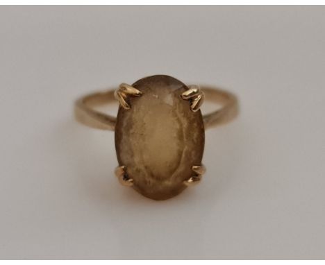 A single yellow stone dress ring, set with an oval cut yellow stone measuring approx. 12x9mm, stamped 9ct, ring size M, weigh