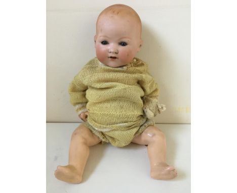An A.M. Germany 651.8.K. porcelain faced doll with composite body snuffers wool outfit with cap. IMPORTANT: Online viewing an