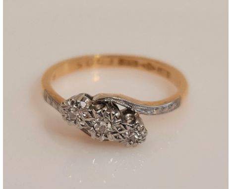 A three stone diamond ring, set with round cut diamonds total weight approx. 0.08ct to crossover design band, stamped 18ct PL