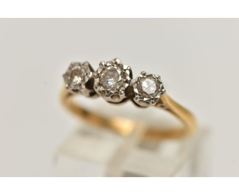 A YELLOW METAL THREE STONE DIAMOND RING, three round brilliant cut diamonds illusion set in a white metal mount, estimated to