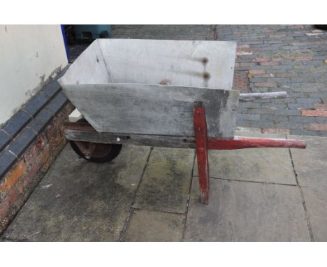 A VINTAGE WOODEN WHEELBARROW with replacement aluminium bucket fitted to old framework, modern wheel and carriage width 52cm 