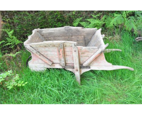 A VINTAGE OAK WHEEL BARROW with cast iron wheel basket width 79cm basket length 113cm at top edge Condition weathered, some l