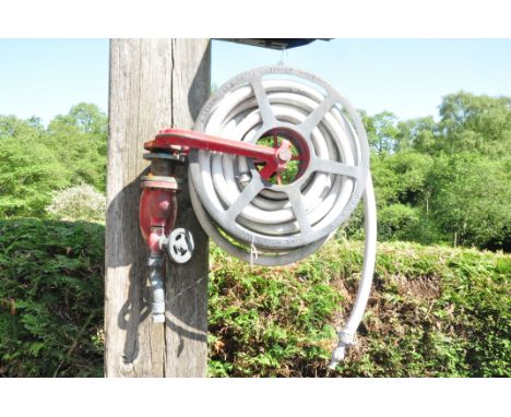 A VINTAGE JOHN MORRIS AND SONS FIRE HOSE REEL with distressed hose and valve reel diameter 46cm width 60cm depth 14cm height 