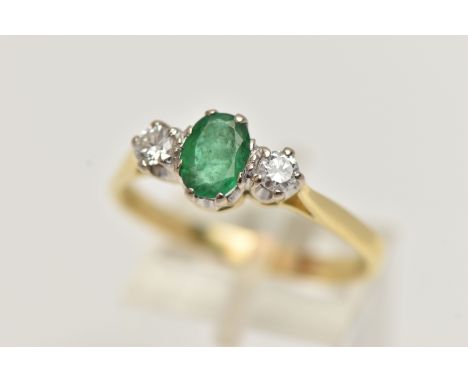 AN 18CT EMERALD AND DIAMOND RING, designed with a central oval cut emerald, claw set, flanked with two round brilliant cut di