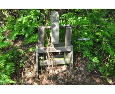 A VINTAGE SHARPENING STONE ON OAK STAND with a 49cm diameter stone width 93cm with handle and height 101cm Condition some los