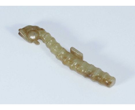 A carved jade belt hook modelled as a stylized dragon. 9cm long.