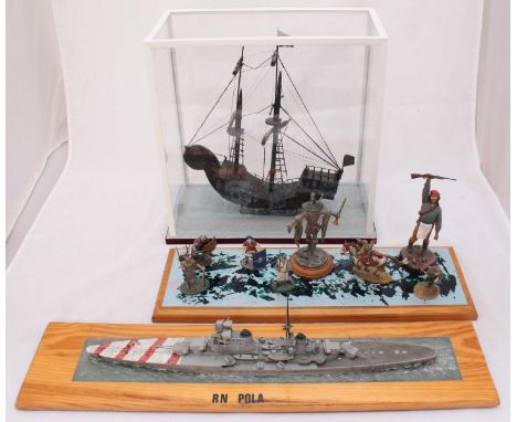 A carved wooden ship in glazed display case, together with a scale model of RN Pola on wooden plinth and some mounted soldier