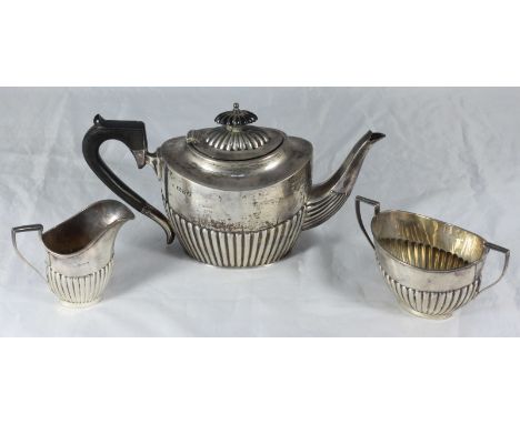 A 'matched' three-piece silver tea set, the teapot by Barker Brothers, hallmarked Chester 1909, all of half-reeded design, gr