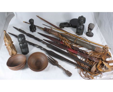 An African tribal leather quiver with bow and metal tipped arrows, together with four African carved wooden daggers, carved b