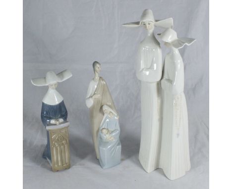 A Lladro figure group of two nuns, approx. 33cm high together with a Lladro figure group of Joseph, Mary and Jesus and a Llad