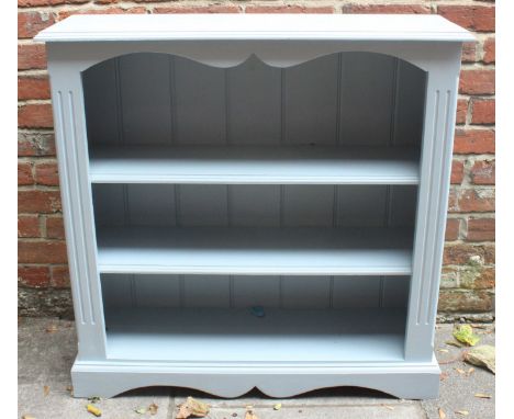 A light blue painted set of three shelves, raised on shaped platform base. 92cm wide.