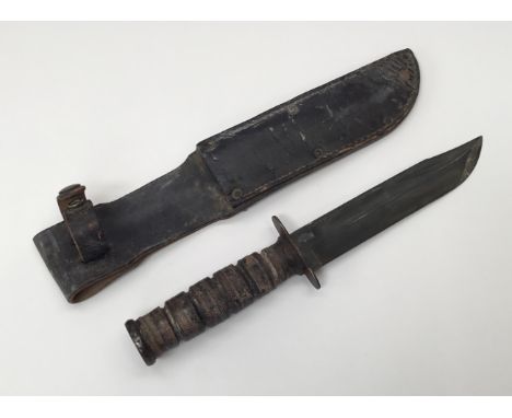 An mid 1970’s United States KA-BAR knife by Camillus. Usual ribbed grip with metal disc pommel, plain steel cross guard, and 