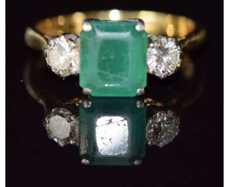 An 18ct gold ring set with an emerald cut emerald and two&nbsp;round cut diamonds, each approximately 0.3ct, 4.1g, size O