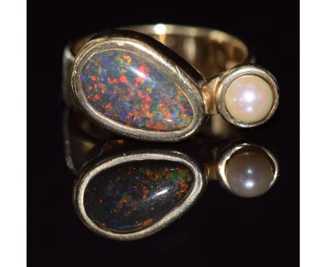 A 9ct gold ring set with a pear shaped black opal cabochon and pearl, 8.7g, size O