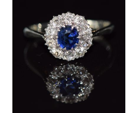 A c1920 18ct white gold ring set with a sapphire surrounded by old cut diamonds, 3g, size M