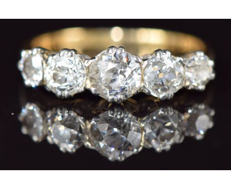 An 18ct gold ring set with five old cut diamonds, the centre diamond approximately 0.45ct, in a platinum setting, 2.7g, size 